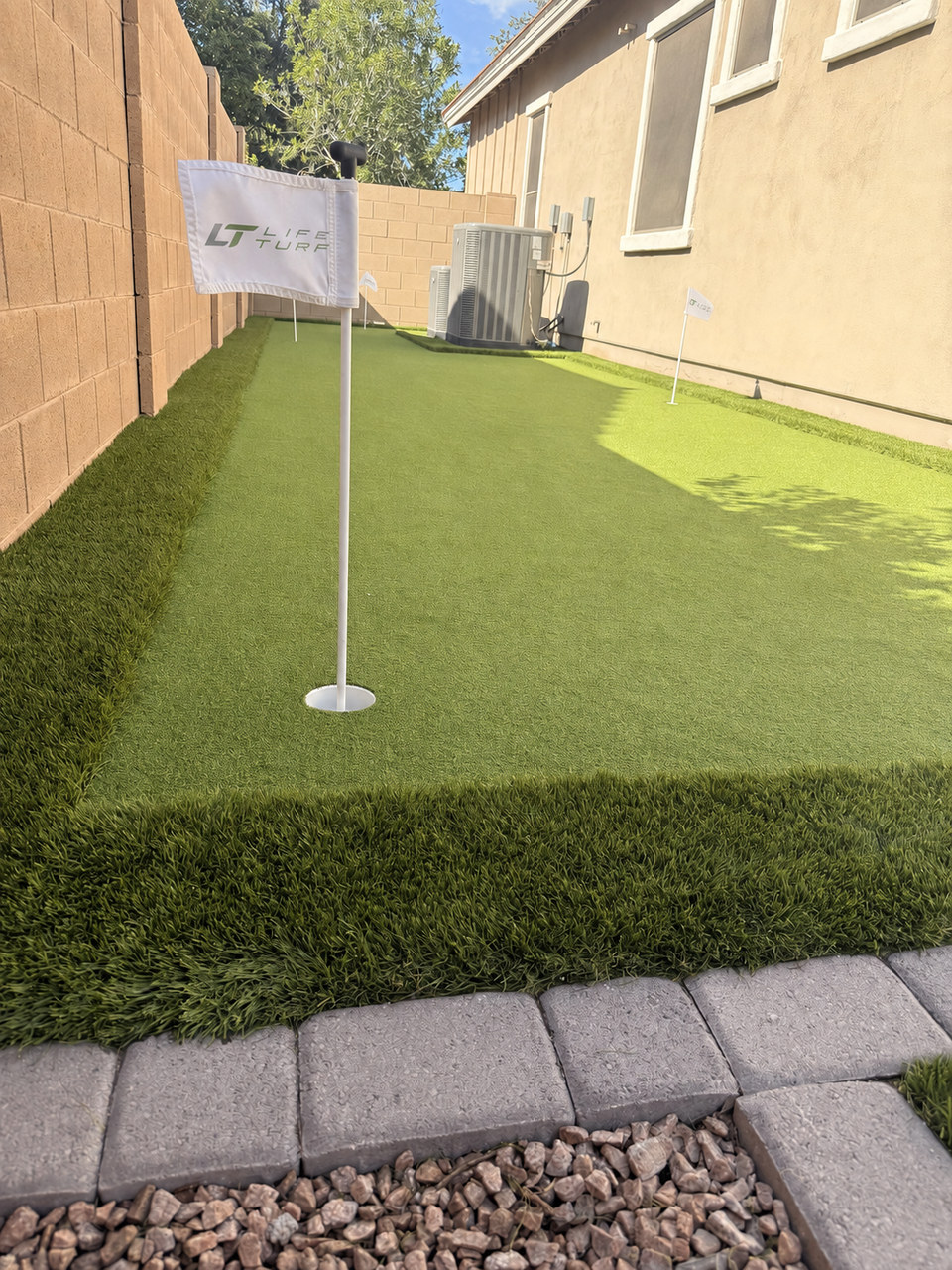 Custom backyard putting green with paver border installed by Life Turf in Arizona