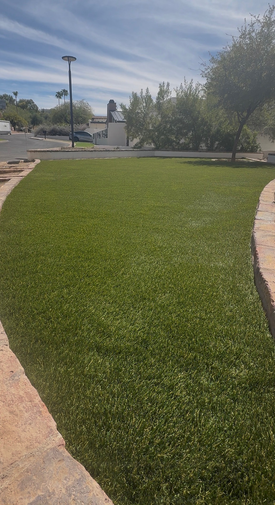 Artificial turf following a curved paver edge in a front yard installed by Life Turf