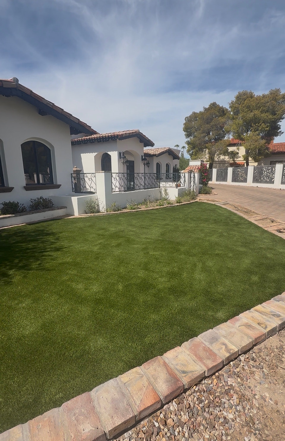 Front yard artificial turf lawn edged with pavers installed by Life Turf